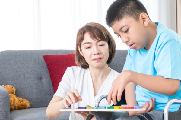 Child with Special Needs Assisted by an Adult