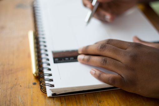 Student's hands using ruler to draw lines on page